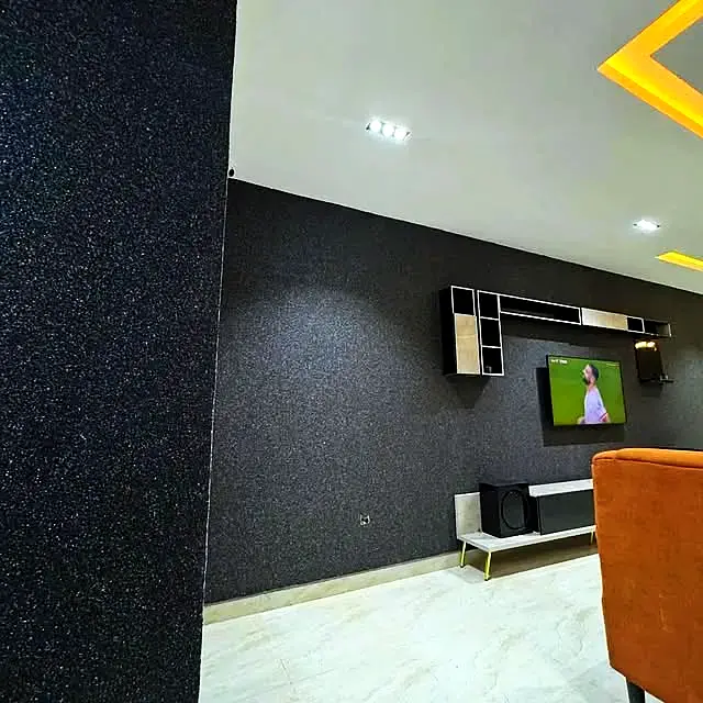 Black marble texture wall behind a TV unit