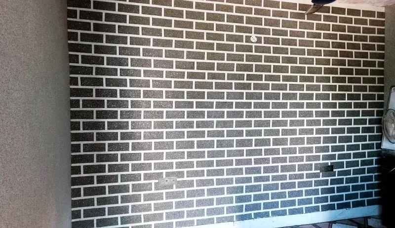 Living-room wall finished in grey marble texture with a brick pattern