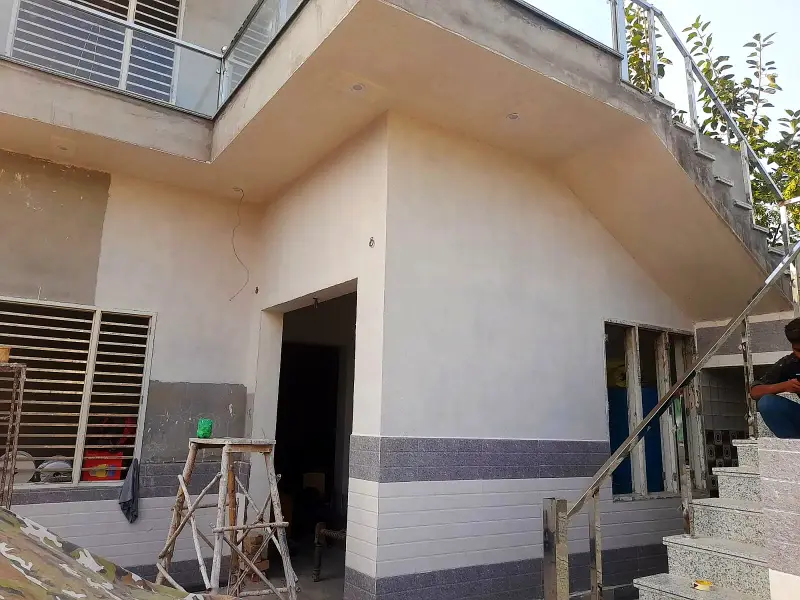 House under work with a grey texture band at the base